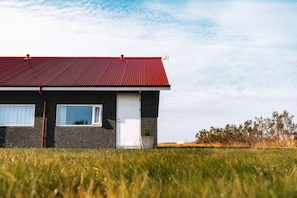 A single-story house with a red roof, a white door, and a window. - Hótel Rjúkandi (Eyja- og Miklaholtshreppur)
