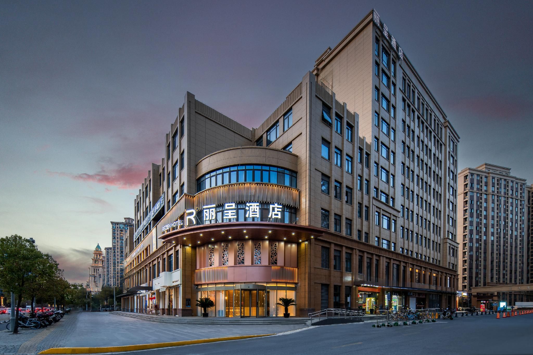 A hotel with a curved facade, multiple floors, and a prominent entrance.
