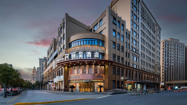Um hotel com fachada curva, vários andares e entrada imponente.
