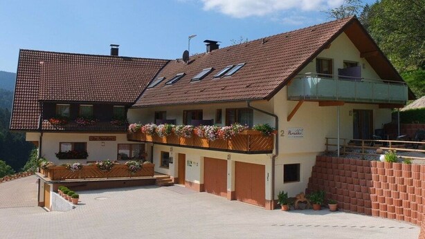 Un bâtiment à deux étages, doté d’un toit en pente, d’un balcon à l’étage supérieur et d’une enseigne indiquant qu’il s’agit d’un restaurant.