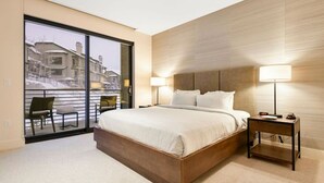 A modern hotel room with a large bed, two bedside tables, a chair, and a view of the outside. - Lift Park City (Park City)