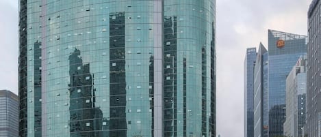 A modern high-rise building with a curved glass facade and a prominent 'INVESTMENT BUILDING' sign at the top.