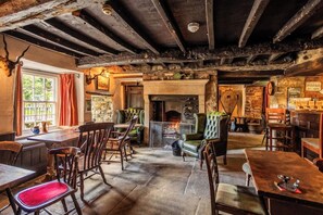 Un intérieur rustique avec des poutres apparentes, une cheminée et des meubles traditionnels.