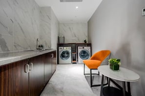 A compact kitchen with marble backsplash, a washing machine, and a small dining area with a table and chair. - Yitel Collection Shanghai Hongqiao Gubei Road Yili Road Metro Station (Shanghai)