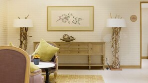 A room with a sofa, a small table, a cabinet, and two lamps.