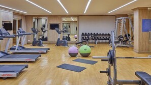 A gym with treadmills, elliptical machines, free weights, and exercise balls. - Twin Lakes Hotel (Laurel)