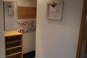 A narrow hallway with a wooden shelf unit and a wall with large, colorful letters. - Holiday home at Maxschacht (Stockheim)