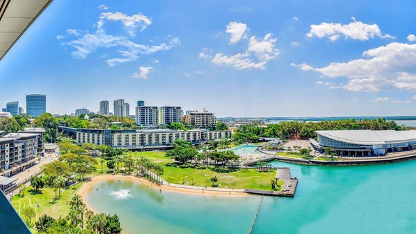 A coastal resort with a swimming pool, a marina, and modern buildings.