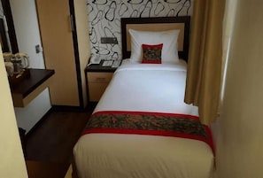 A hotel room with a bed, a bedside table, a nightstand, and a wall with a pattern. - Treeli Boutique Hotel (Bukittinggi)