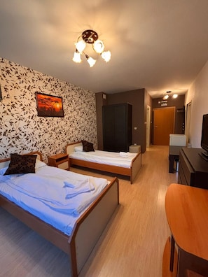 A hotel room with two single beds, a wooden desk, a wardrobe, and a painting on the wall. - Hotel Iceberg Borovets (Samokov)