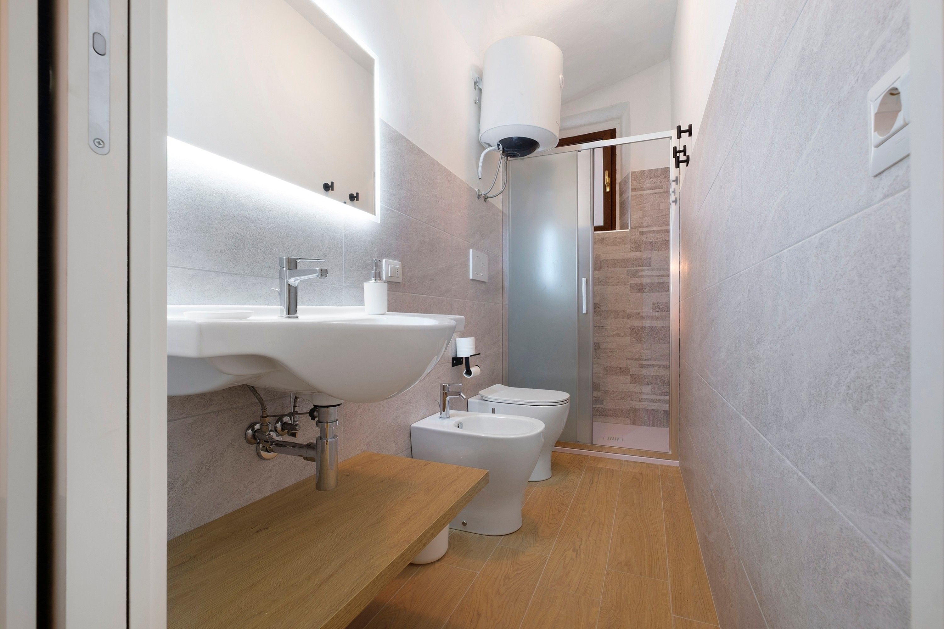 Un baño moderno con lavamanos, inodoro y ducha.