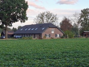 A brick house with a sloped roof and multiple windows. - Vrbo Property (Aarle-Rixtel)
