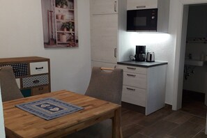 A compact kitchen with a microwave, coffee maker, and a small countertop. - Holiday apartment in Ettal with barbecue (Ettal)
