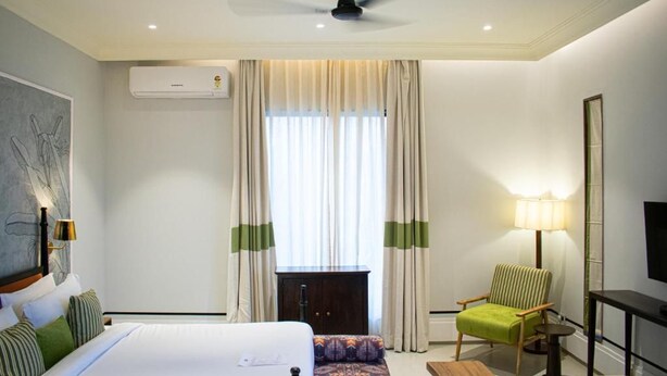 A hotel room with a bed, a desk, a chair, a lamp, and a television. - The Sierra-a Luxury Stay (Udaipur)