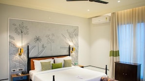 A bedroom with a bed, nightstands, a wardrobe, and a ceiling fan. - The Sierra-a Luxury Stay (Udaipur)