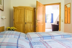 Ein Schlafzimmer mit einem Bett, einem Kleiderschrank und einer Tür, die auf einen Balkon führt.