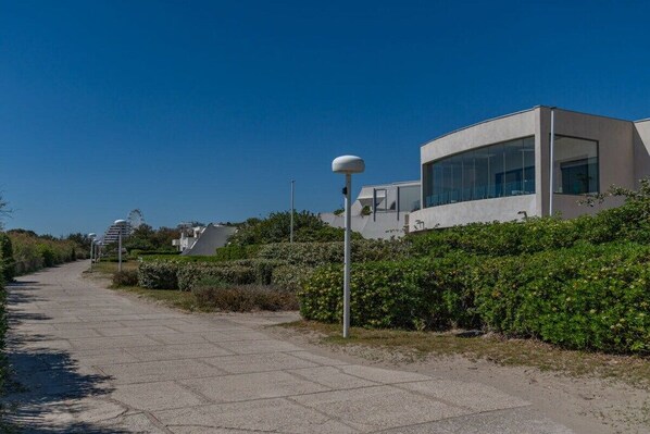 A modern building with large windows and a paved pathway.