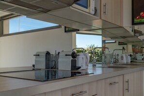 A modern kitchen with a built-in microwave, toaster, and coffee maker on a countertop.