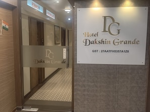La entrada del Hotel Dakshin Grande con un cartel que muestra el nombre y el número GST.