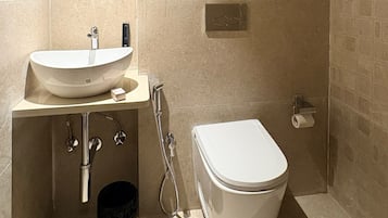 A bathroom with a white sink, toilet, and shower.