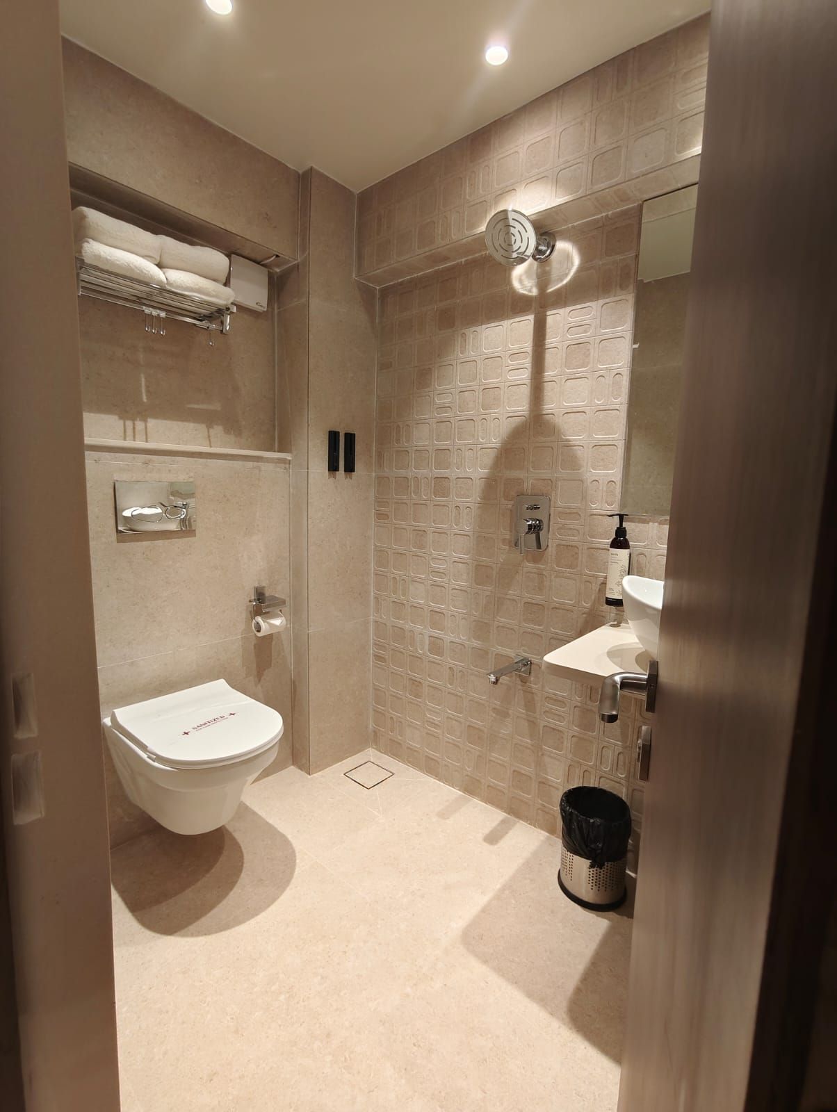 Un baño moderno con inodoro, lavamanos y zona de ducha.