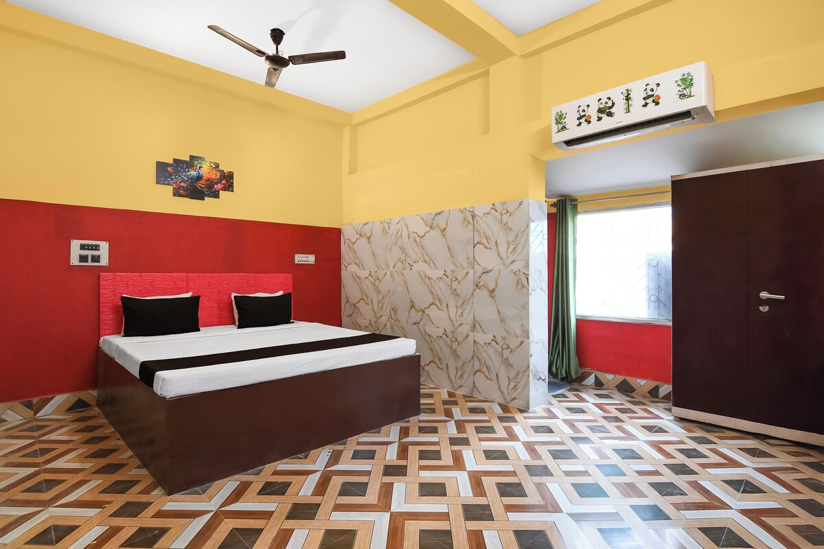 Un dormitorio con cama, ventilador de techo, ventana con cortinas y aire acondicionado instalado en la pared.
