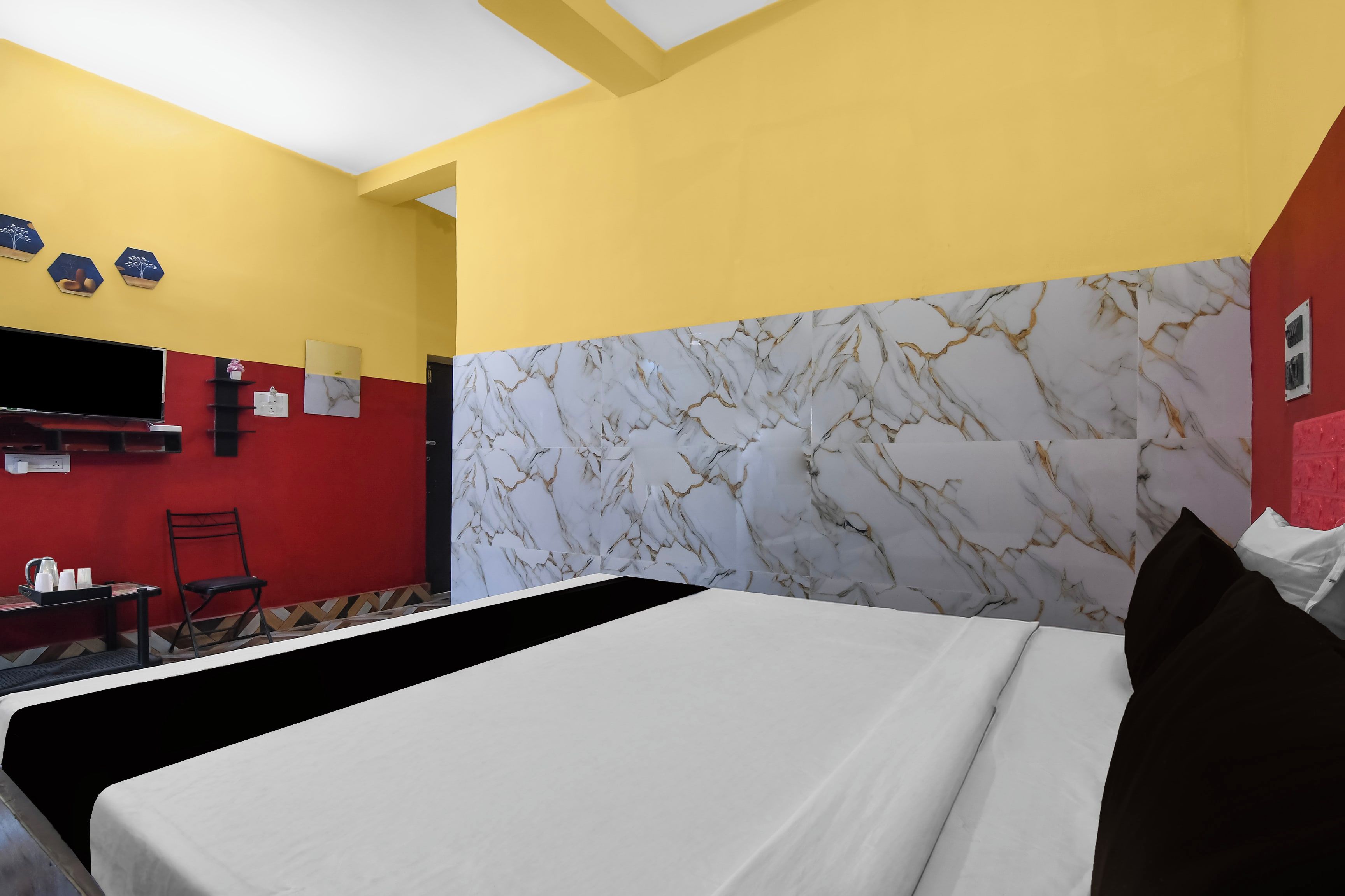 A hotel room with a bed, a desk, and a chair.