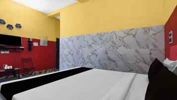 A hotel room with a bed, a desk, and a chair.
