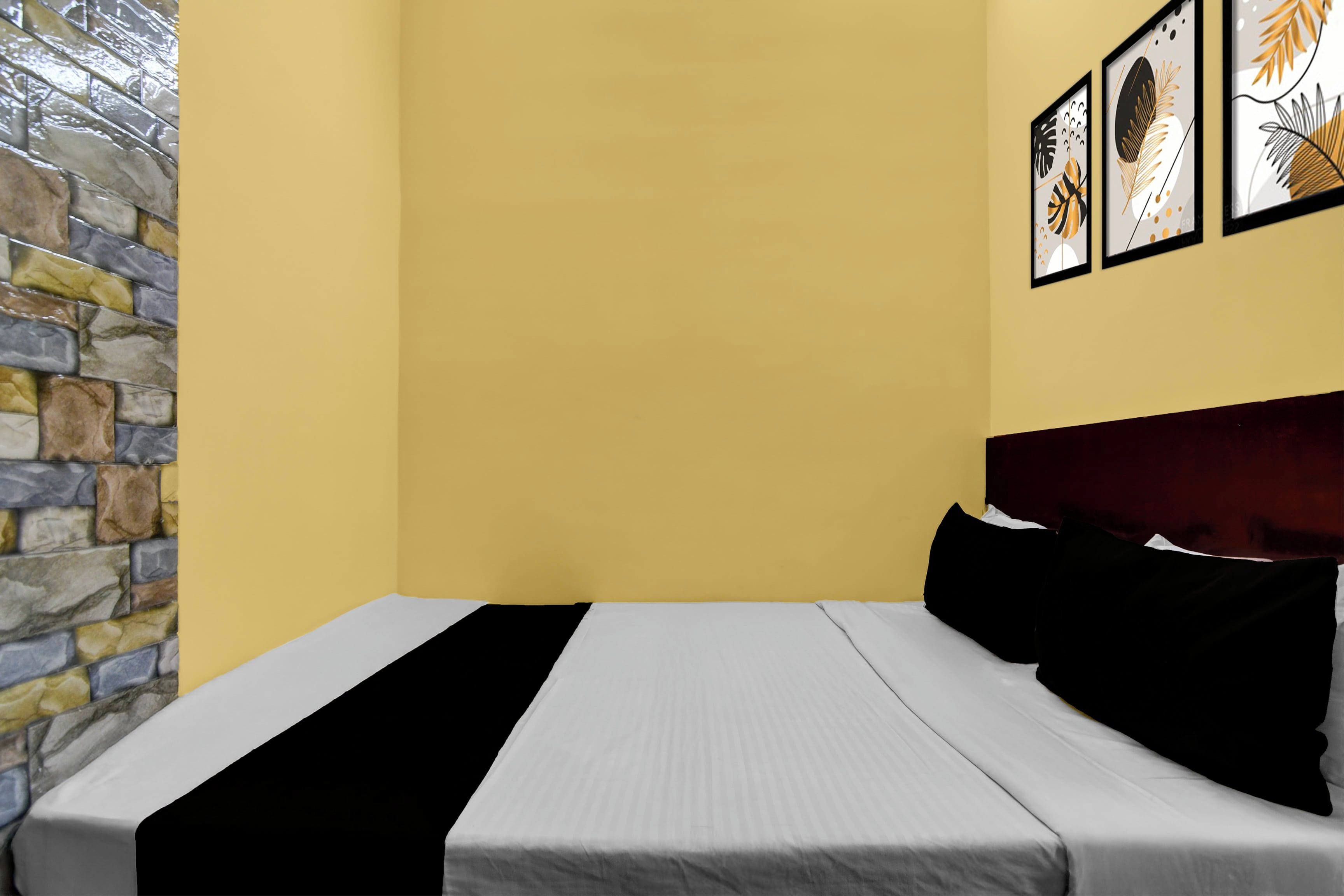Habitació amb un llit, paret de pedra i obra d'art a la paret.