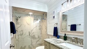 A bathroom with a shower, toilet, vanity with a sink, and a mirror. - 8th Floor Oasis! Beautiful Gulf front views! (Panama City Beach)