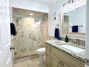 A bathroom with a shower, toilet, vanity with a sink, and a mirror. - 8th Floor Oasis! Beautiful Gulf front views! (Panama City Beach)