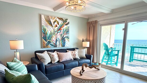 A living room with a sofa, a round coffee table, and a painting on the wall. - 8th Floor Oasis! Beautiful Gulf front views! (Panama City Beach)