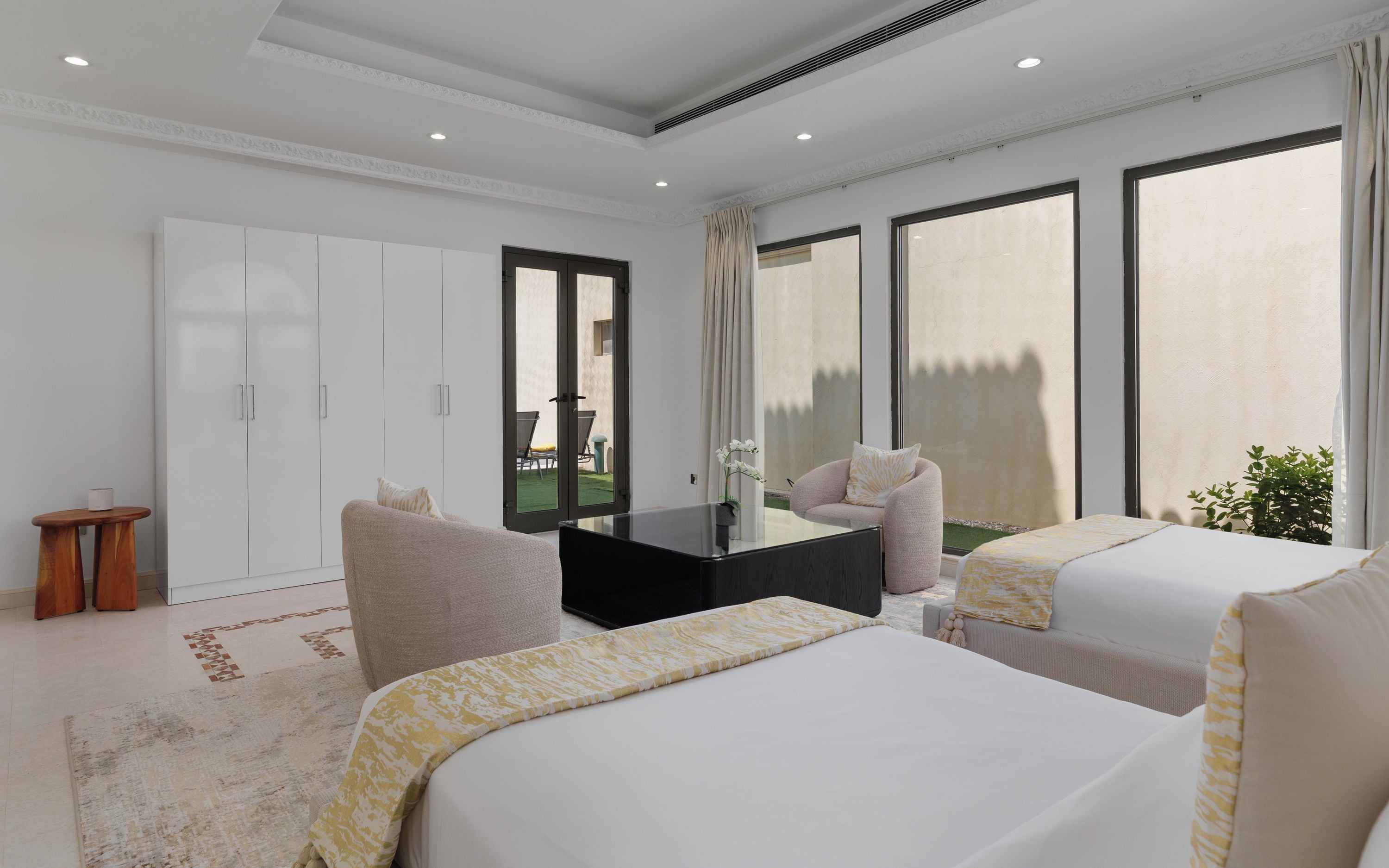 A modern hotel room with a large bed, a desk, and a view of the outdoors.