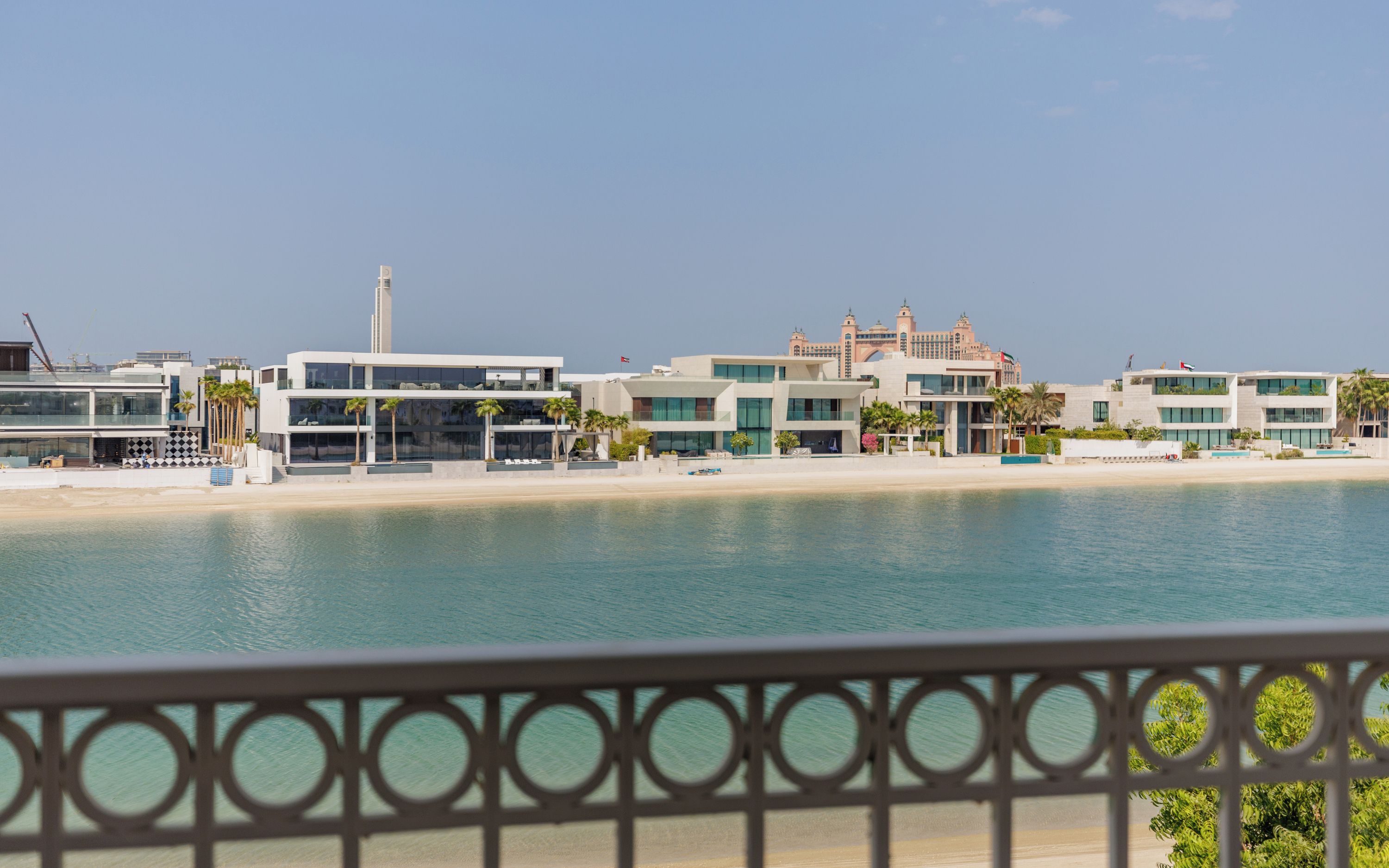 A coastal hotel with a beachfront view, modern architecture, and a pool area.