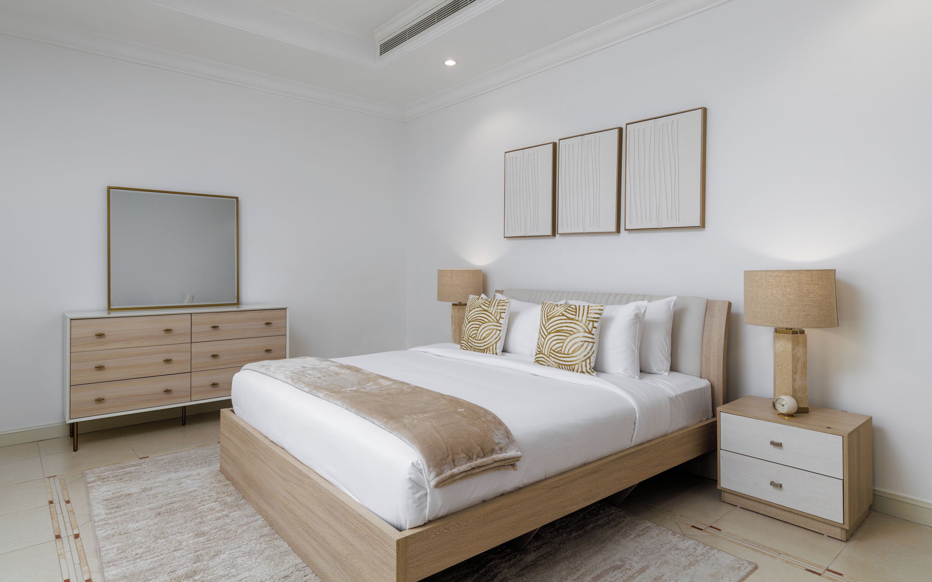 Une chambre à coucher avec un lit en bois, des tables de chevet, une commode et un miroir.