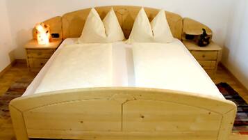 A bed with a wooden headboard and two bedside tables with lamps.