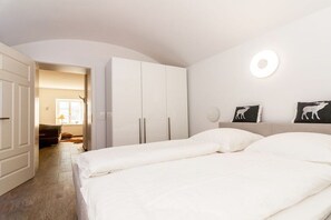 Ein Schlafzimmer mit einem Bett, einem Kleiderschrank und einer Wandleuchte.