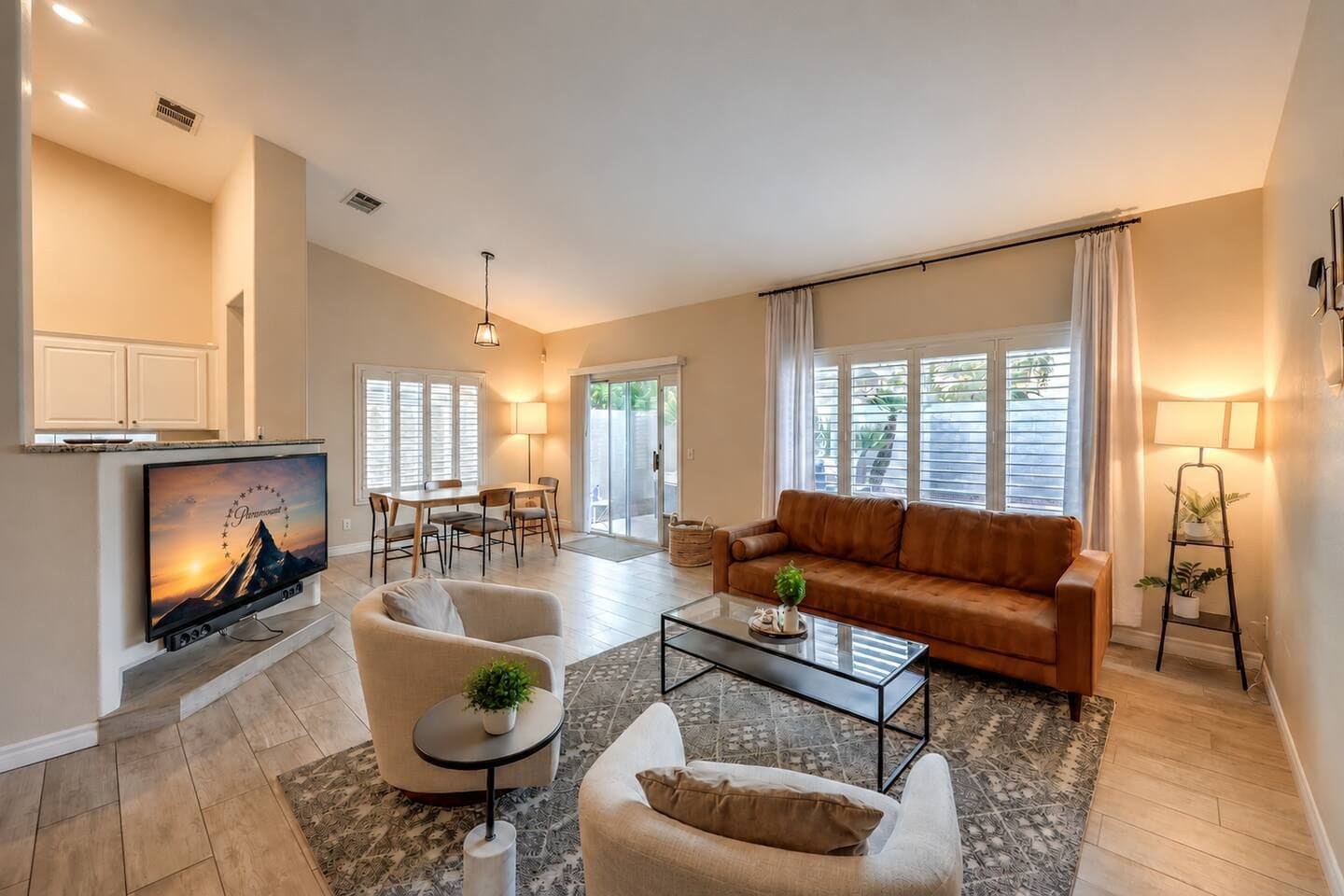 A living room with a sofa, two armchairs, a coffee table, and a TV.