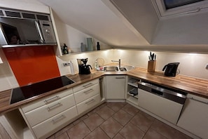 A compact kitchen with a microwave, coffee maker, and a dishwasher. - Alpenflair holiday apartment 402 (Oberstdorf)
