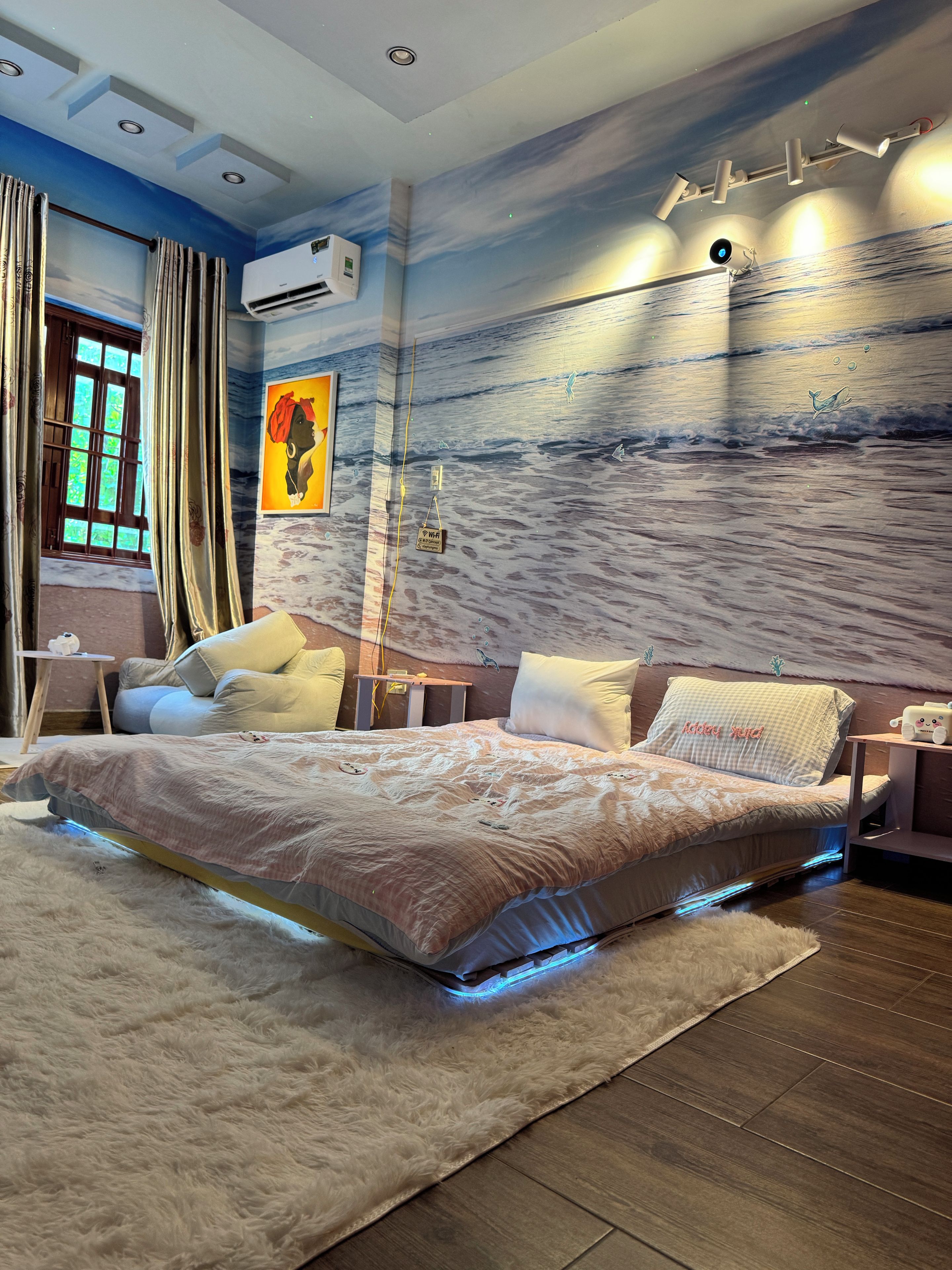 Ein modernes Schlafzimmer mit einem großen Bett, einem Nachttisch, einer Wand-Klimaanlage und einer Decke mit Einbauleuchten.
