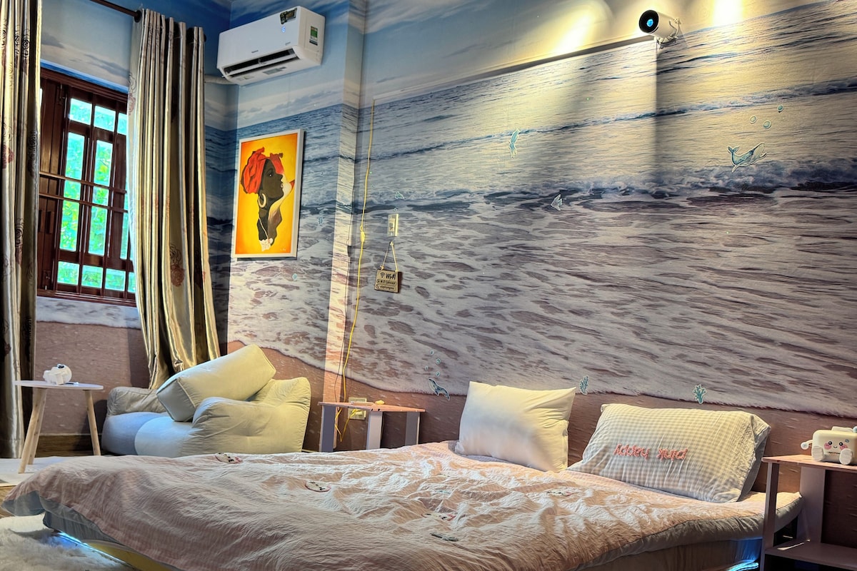Un dormitorio moderno con una cama grande, una mesita de noche, aire acondicionado de pared y techo con iluminación empotrada.