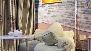 A modern living room with a sofa, a small table, and a painting on the wall.