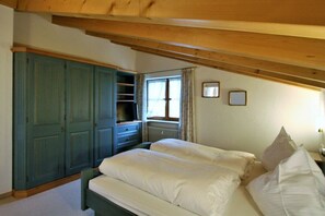 A bedroom with a bed, a wardrobe, a window, and a radiator. - Alpenflair holiday apartment 230 (Oberstdorf)
