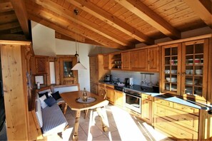 A wooden interior with a dining area, kitchen, and built-in cabinets. - Alpenflair holiday apartment 230 (Oberstdorf)