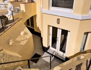 Ein mehrgeschossiges Gebäude mit einer zentralen Treppe, einer Löwenstatue und einem Fenster mit Jalousien.