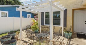 A patio with a pergola, outdoor seating, and potted plants. - Pinetree Palace - 4BR Cozy Home (Panama City Beach)