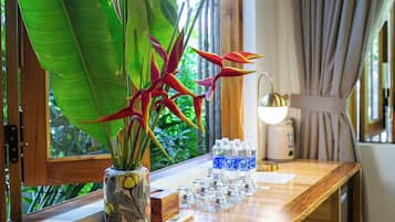 A wooden desk with a potted plant, a water dispenser, and a remote control.