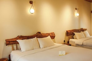 Una habitación de hotel con dos camas, cada una con cabecera de madera, ropa de cama blanca y una pequeña tarjeta sobre la cama.