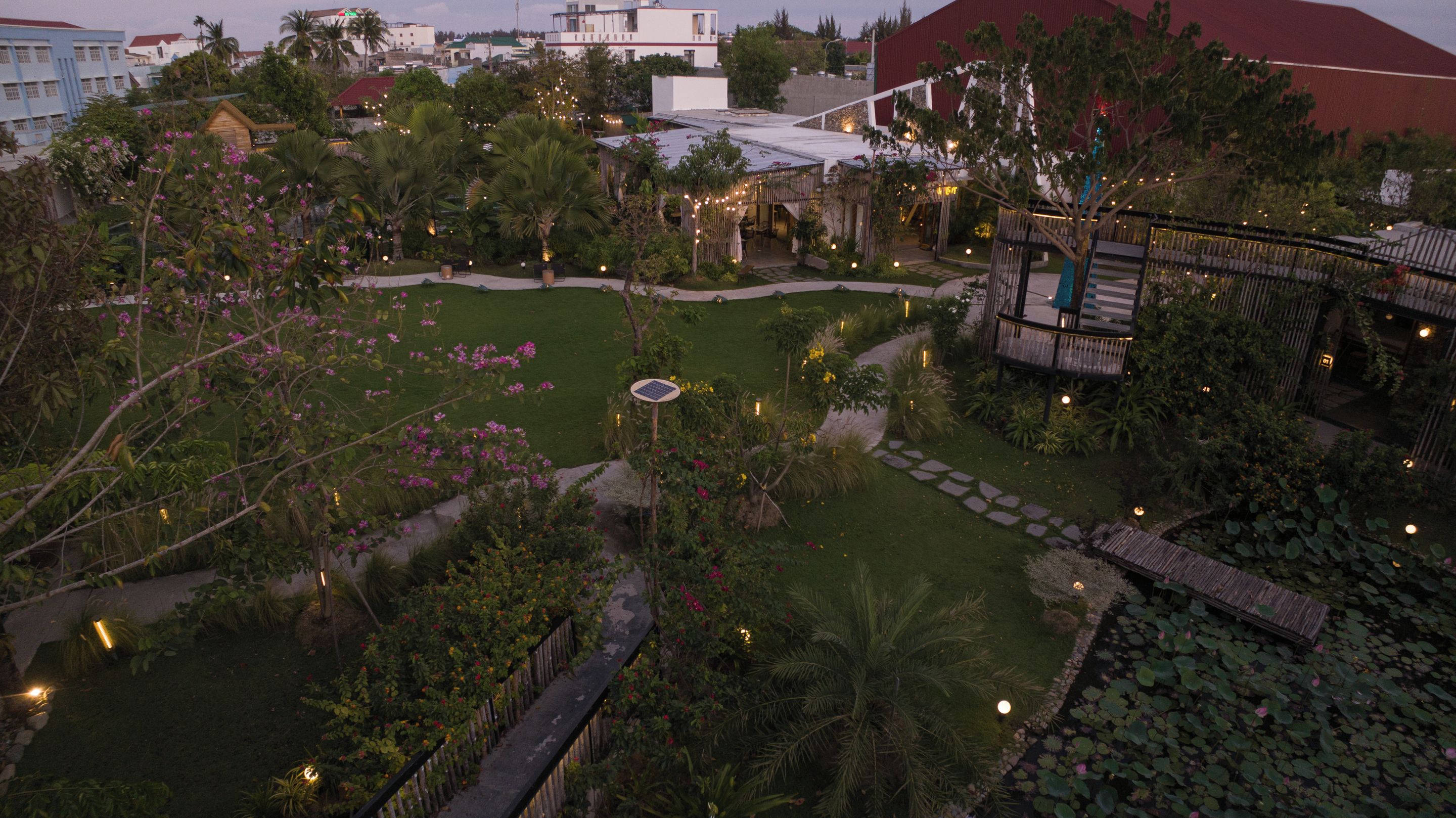 A landscaped garden with a pond, pathways, and a wooden deck.