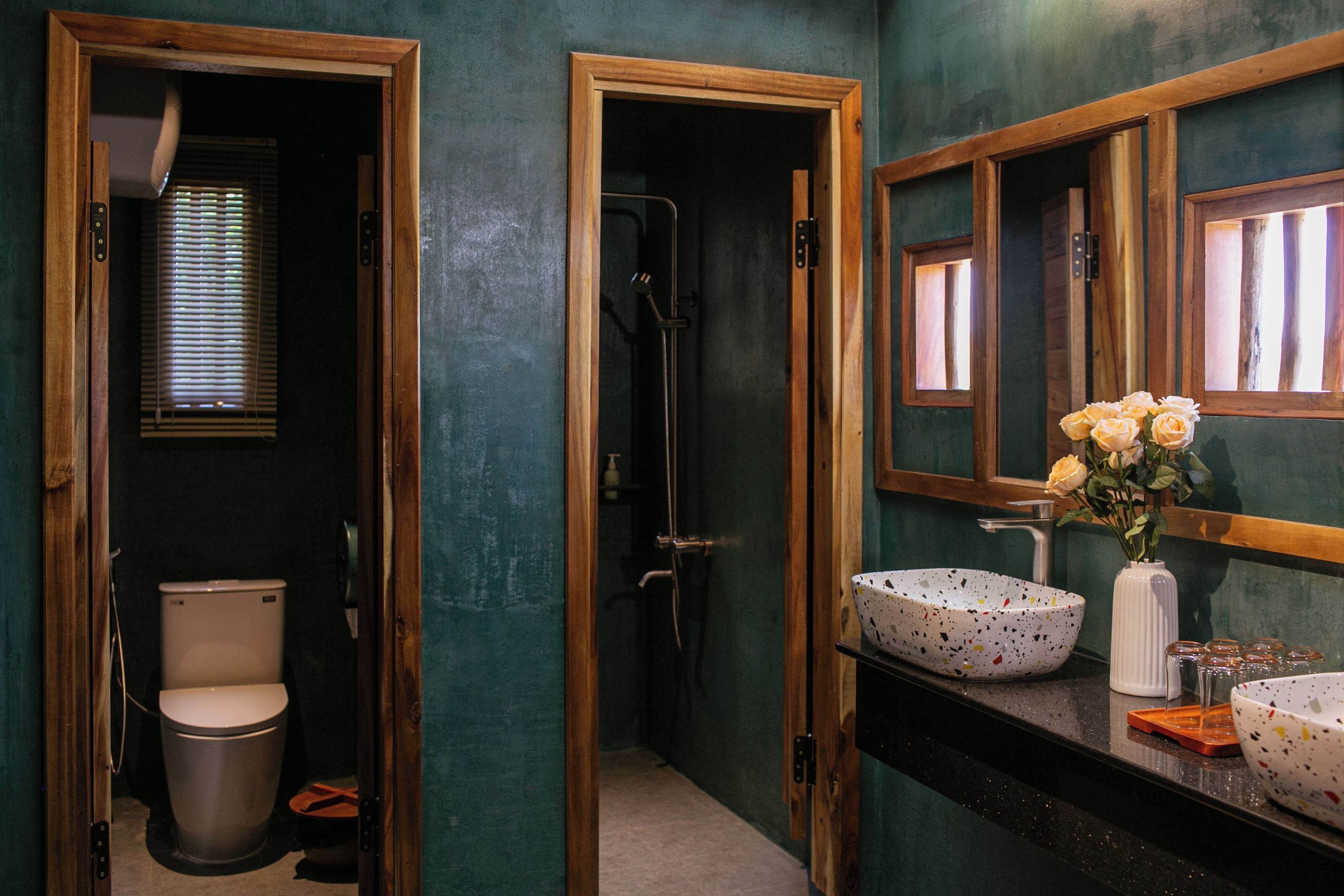 Un baño con inodoro, ducha, lavabo y espejo.